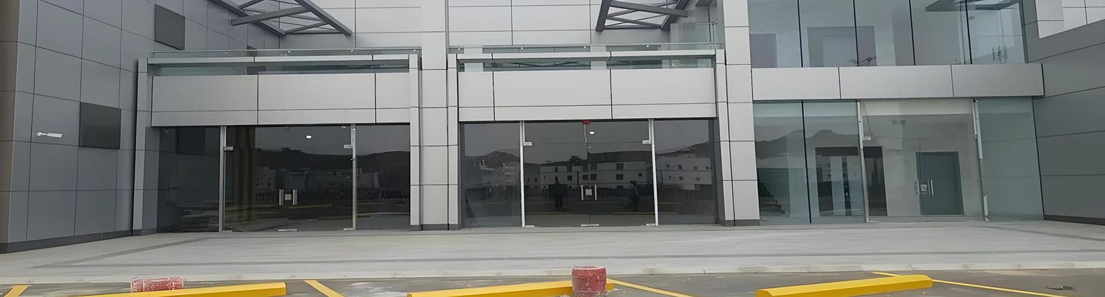 The finished Bank Al Rajhi building in Taif: glazed shopfronts under aluminium composite cladding